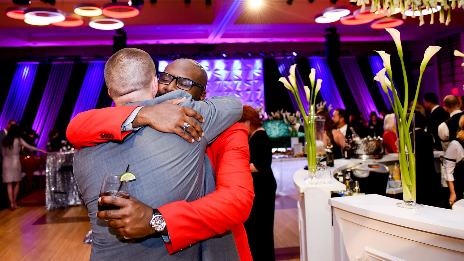 Two men embrace at an NC State Red and White Night event.